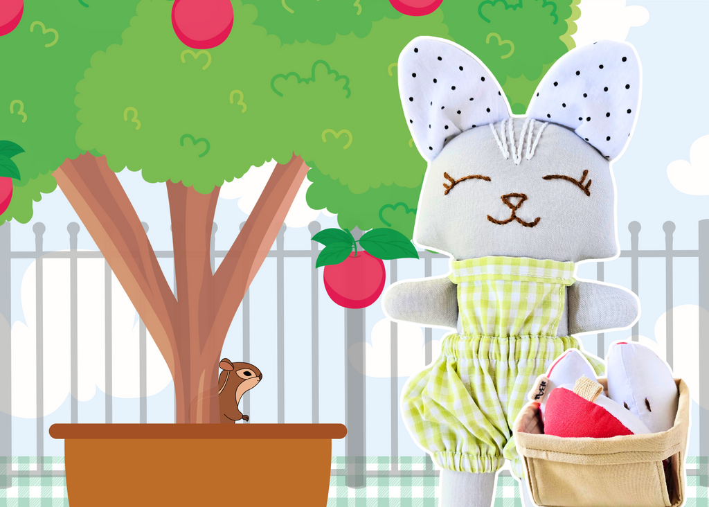 Toy figure of a cat in an apple green outfit standing next to a tree with apples and a chipmunk.