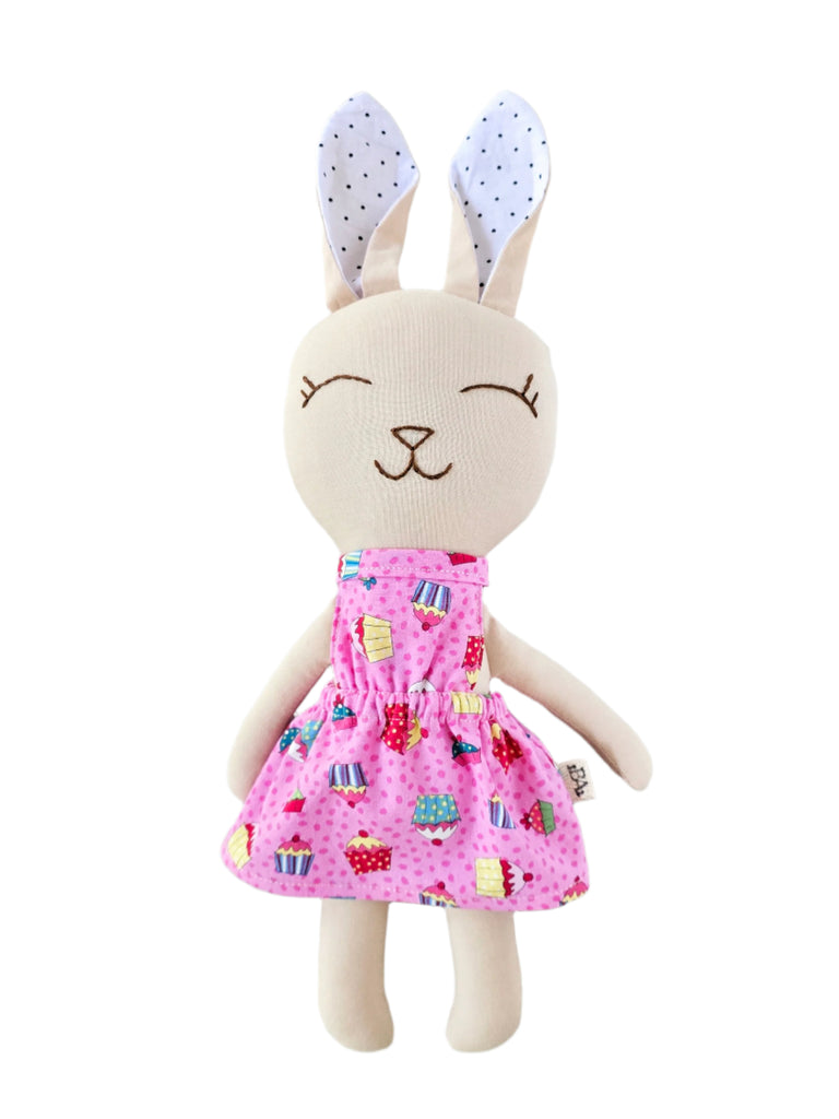 Stuffed bunny toy with a pink dress on a white background