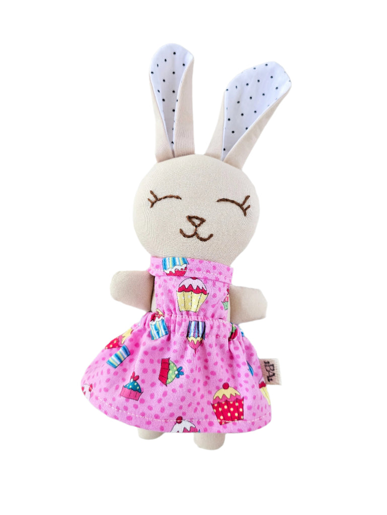 Toy rabbit with a pink dress on a white background